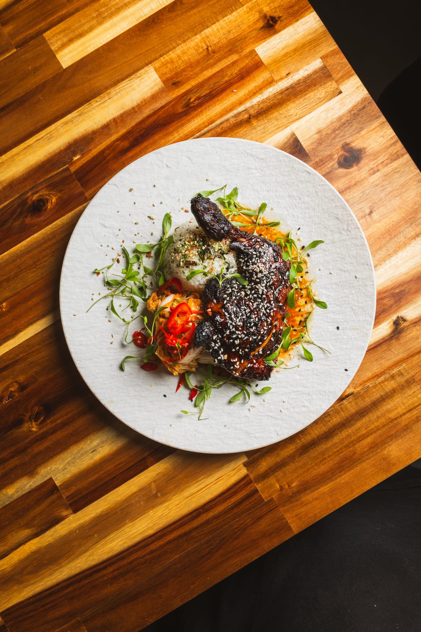 Black sesame-crusted dish on a rustic table