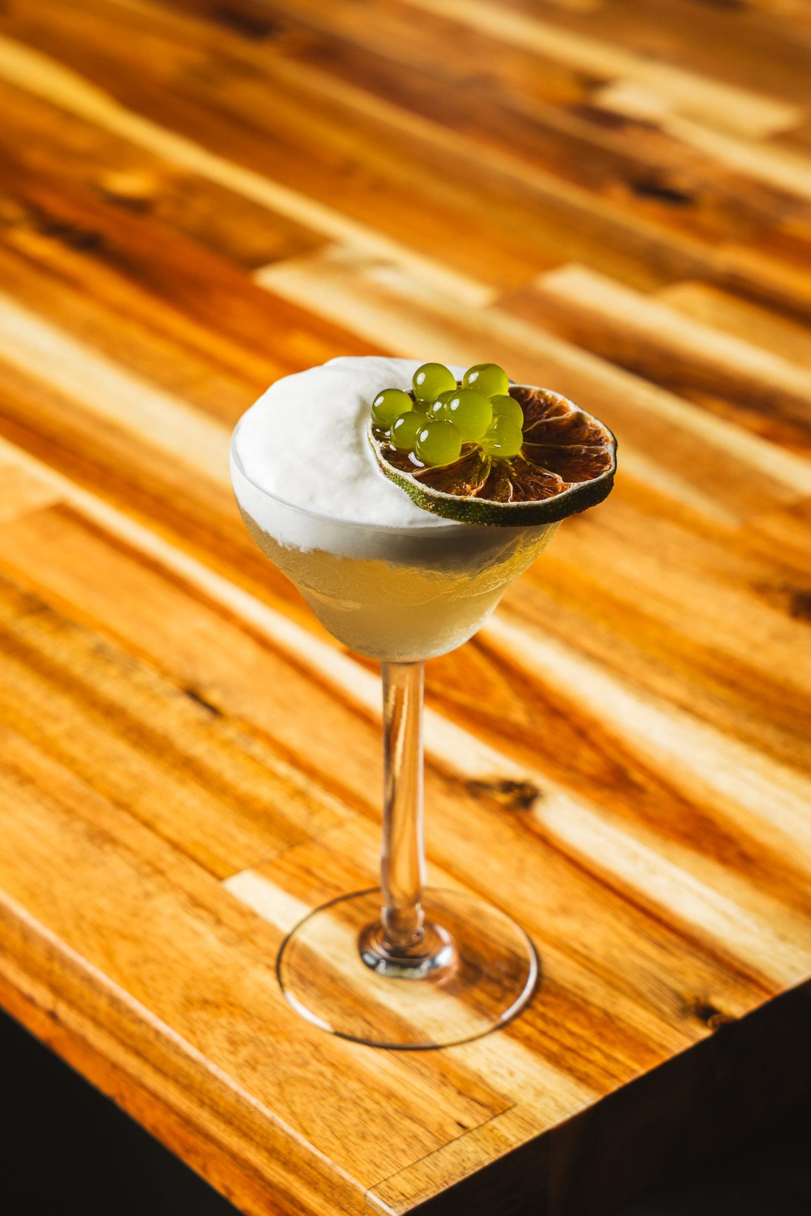 Coupe cocktail with a delicate herb garnish